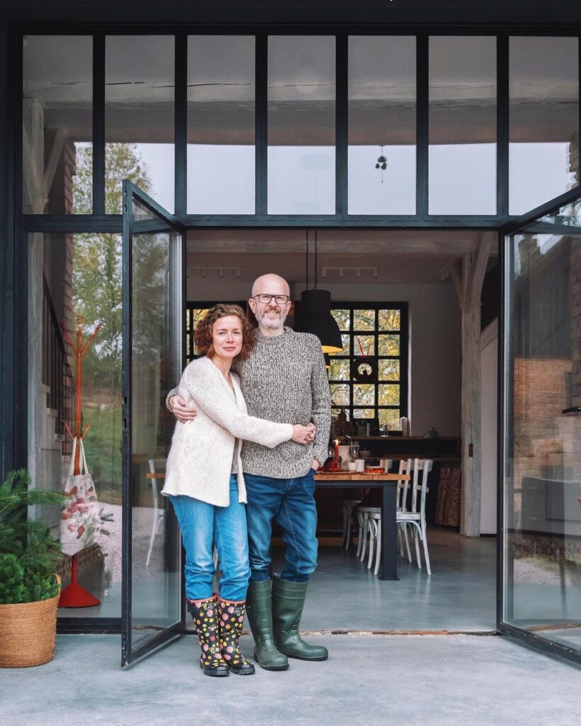 Beata i Witek, gospodarze domu gościnnego tylko dla dorosłych Rajskie Jabłka, stoją w otwartych drzwiach domu w Pławnej Górnej na Pogórzu Izerskim